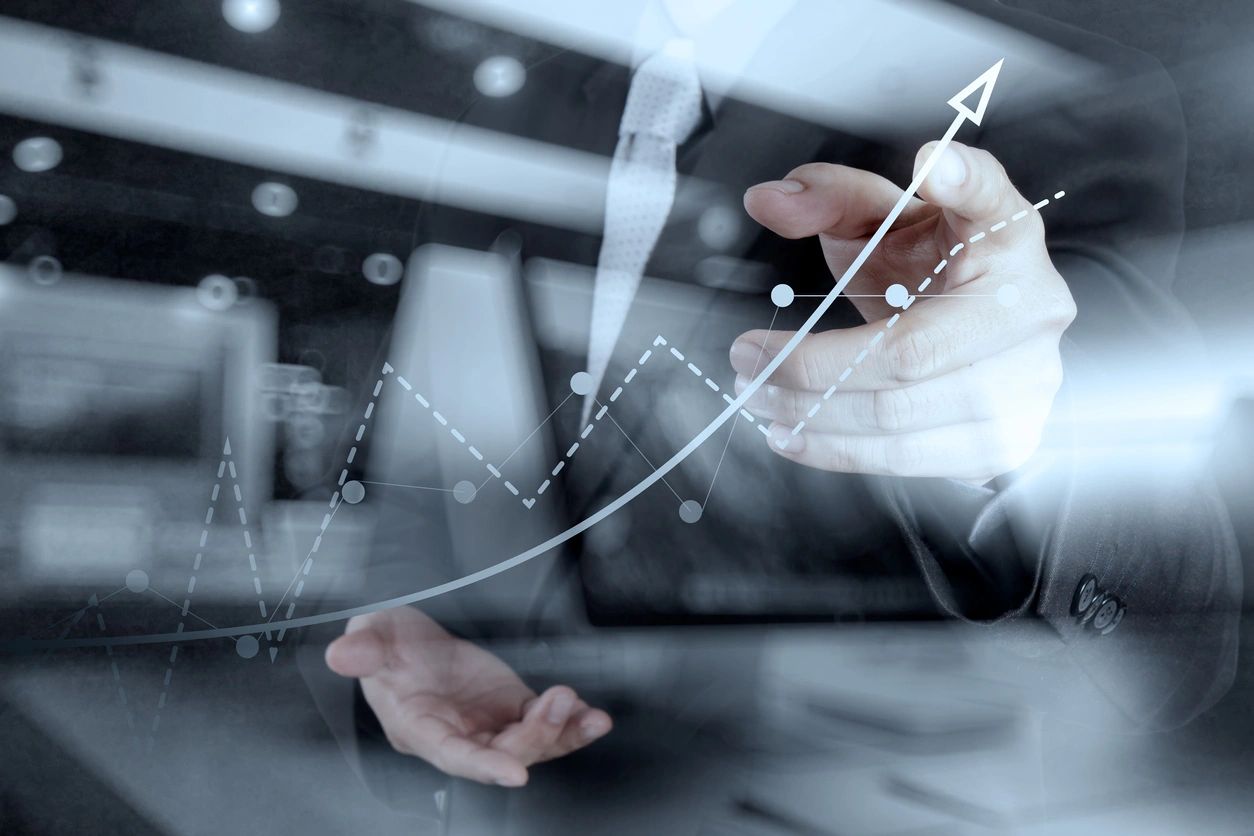 Person holding a line graph in front of a window, illustrating data trends and performance metrics for business analysis